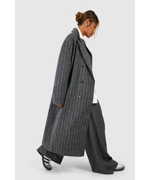 Oversized silhouette for a bold, contemporary look
        Classic pinstripe pattern adds sophistication
        Notched lapels and long sleeves for timeless appeal
        Versatile wool-look fabric suitable for various occasions
        Longline design for dramatic flair and extra warmth
    
    Make a striking statement with this pinstripe oversized coat, perfect for the fashion-forward individual who appreciates a blend of classic and modern styles. The generous cut allows for effortless layering over chunky knits or sleek tailoring, making it an ideal choice for transitional weather. Style it with wide-leg trousers and trainers for a chic, relaxed look, or pair it with a crisp white shirt and tailored trousers for more formal events. The timeless pinstripe pattern ensures this coat will remain a wardrobe staple for seasons to come, while its versatility allows for endless styling possibilities. Whether you're heading to the office, a smart-casual dinner, or a weekend brunch, this coat will keep you looking polished and on-trend.