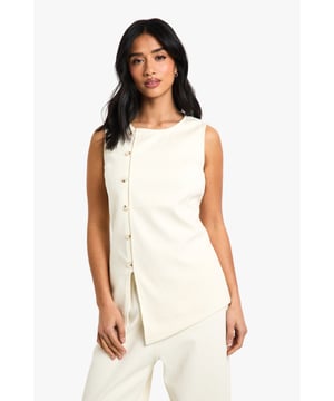 Sleeveless cord waistcoat with high neckline for a sophisticated silhouette
        Asymmetric button-through front detail adding contemporary flair
        Structured woven cotton fabric providing excellent shape retention
        Versatile petite fit designed specifically for smaller frames
        Sleek, clean-lined design perfect for layering or wearing alone
    
    This cord waistcoat reimagines a classic silhouette with modern asymmetric detailing, making it a standout piece for your evening wardrobe. The structured cotton fabric creates a flattering shape that works brilliantly for petite frames, whilst the high neckline adds a touch of sophistication. Style as seen with coordinating wide-leg trousers and pointed heels for a chic monochromatic ensemble that's perfect for drinks with the girls. For cooler evenings, layer over a fitted turtleneck or under a tailored blazer. Alternatively, dress it down with your favourite denim and trainers for casual drinks. The versatile design transitions effortlessly from day to night, making it an essential addition to your Boohoo collection that will see you through multiple social occasions with style and confidence.