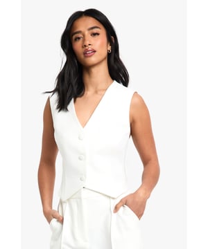 Sleek V-neckline for a flattering silhouette
        Boxy fit design for a contemporary look
        Button-front closure adds a classic touch
        Versatile sleeveless style perfect for layering
        Cropped length ideal for high-waisted bottoms
    
    Embrace effortless chic with this essential petite waistcoat from Boohoo. The boxy fit and sleeveless design offer a modern twist on a timeless classic, making it a versatile addition to your wardrobe. Style it with matching wide-leg trousers for a coordinated ensemble that's perfect for casual gatherings or family events. For a more relaxed look, pair it with your favourite jeans and trainers. Layer it over a crisp white shirt for a smart-casual office outfit, or throw it on over a flowy dress for an unexpected edge. The possibilities are endless with this adaptable piece, allowing you to create multiple looks for various occasions. Remember to keep accessories minimal to let this waistcoat shine as the focal point of your outfit.