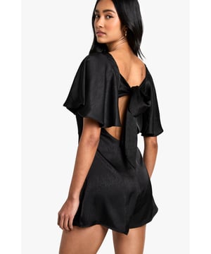 Elegant boat neckline with dramatic wide flutter sleeves for a sophisticated silhouette
        Striking open back design with stylish tie detail for added allure
        Flattering fitted waist that accentuates your natural shape
        Smooth, lightweight fabric that drapes beautifully for comfortable all-night wear
        Versatile short length perfect for showcasing your legs
    
    Make a statement on your next night out with this captivating playsuit from Boohoo. The elegant boat neckline and wide flutter sleeves create a dramatic yet refined look, while the open back with tie detail adds an unexpected twist that's sure to turn heads. Perfect for those evenings when you want to stand out from the crowd, this playsuit pairs brilliantly with strappy heels and a metallic clutch as shown by our model. For cooler evenings, layer with a cropped jacket without compromising on style. The fitted waist and short length create a flattering silhouette that works wonderfully for drinks with the girls, club nights, or sophisticated cocktail bars. Accessorise with statement earrings and a sleek updo to highlight the beautiful back detail for maximum impact.