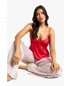Charming cherry print pyjama set for tall frames
        Sleek camisole top with adjustable straps
        Wide-leg trousers for ultimate comfort
        Contrasting solid top and patterned bottom design
        Lightweight fabric for a cool and cosy night's sleep
    
    Indulge in sweet dreams with this delightful cherry print pyjama set, specially designed for taller figures. The ensemble features a chic camisole top with a flattering V-neckline and delicate adjustable straps, paired with wide-leg trousers that offer unrestricted movement. The contrast between the solid-coloured top and the playful cherry-printed bottoms adds a touch of whimsy to your nighttime routine. Perfect for lounging, this set strikes the ideal balance between style and comfort. Whether you're having a relaxed night in or hosting a pyjama party with your mates, this versatile set will keep you feeling fabulous and looking effortlessly stylish. The lightweight fabric ensures a cool and comfortable sleep, making it suitable for year-round wear. Embrace your inner fashionista even as you drift off to dreamland in this trendy Boohoo pyjama set.