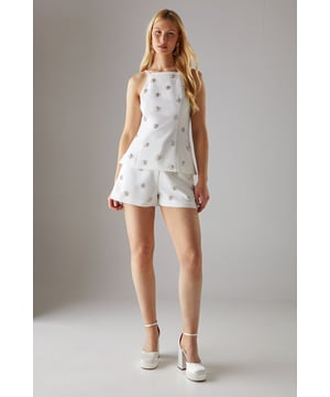 Sophisticated tailored shorts featuring delicate embellishment throughout for a distinctive look
        High-waisted design with a clean, streamlined silhouette for a flattering fit
        Subtle back pockets maintain the sleek aesthetic while offering practicality
        Versatile mid-thigh length perfect for both day and evening occasions
        Slight stretch in the fabric ensures comfort without compromising on structure
    
    These embellished tailored shorts from Warehouse showcase refined craftsmanship with their structured silhouette and eye-catching embellishments. The high-waisted design creates a leg-lengthening effect whilst the tailored cut offers a sophisticated edge to your going-out wardrobe. Style with a matching embellished top as shown for a coordinated set that commands attention, or break up the look with a crisp white blouse for cocktail events. For evening soires, pair with strappy heels and statement jewellery to amplify the glamour. When the temperature drops, layer with a cropped blazer to maintain the polished aesthetic. These shorts transition seamlessly from sunset drinks to late-night dancing, making them a versatile addition to your night-out collection.
