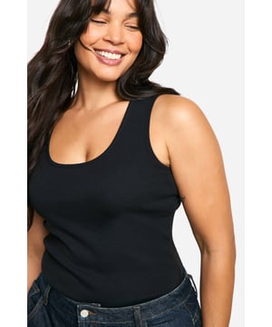 Ribbed jersey fabric for a comfortable, body-hugging fit
        Wide straps offer ample support and coverage
        Scoop neckline adds a feminine touch
        Versatile design suitable for layering or wearing alone
        Figure-flattering silhouette enhances curves
    
    This plus-size ribbed tank top from Boohoo is a wardrobe essential that combines style with comfort. The wide straps and scoop neckline create a flattering silhouette, while the ribbed jersey fabric ensures a snug fit that moves with you. Perfect for casual outings, this versatile piece can be styled in numerous ways. Pair it with high-waisted jeans and trainers for a relaxed daytime look, or dress it up with a midi skirt and statement jewellery for evening drinks with friends. Layer it under a blazer for a smart-casual office ensemble, or throw on a cardigan for family gatherings. The tank's adaptability makes it ideal for mixing and matching with various bottoms and accessories, allowing you to create multiple outfits for different occasions. Embrace your curves and feel confident in this chic, body-positive staple that's designed to complement your figure.