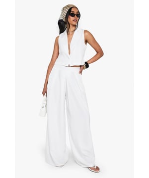 Wide leg silhouette for a relaxed, flowing fit
        High-waisted design with pleated front detail
        Sleek side pockets for practicality
        Cropped, sleeveless top with plunging neckline
        Versatile two-piece set for mix-and-match styling
    
    Make a statement in this chic wide-leg trouser set that combines comfort with urban sophistication. The high-waisted design elongates your silhouette, while the pleated front adds a touch of tailored elegance. Pair with the matching cropped top for a coordinated look that's perfect for a night out on the town. The plunging neckline of the top adds a daring edge, ideal for those looking to turn heads at the bar or club. For a more versatile approach, style the trousers with a fitted bodysuit and strappy heels, or dress down the top with high-waisted jeans for drinks with friends. This set is a must-have for the fashion-forward woman who values both style and comfort in her nightlife wardrobe. Accessorise with bold jewellery and a clutch bag to complete your going-out ensemble.