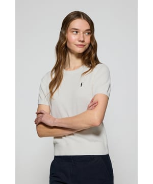 Dieser kurzärmlige Damenstrickpullover ist die perfekte Kombination aus Eleganz und Komfort. Er ist aus weicher Baumwolle gefertigt und hat eine reguläre Passform, die sich sanft an die Silhouette anschmiegt. Der Rundhalsausschnitt und die gerippten Abschlüsse an den Ärmeln, am Kragen und am Bund sorgen für einen bequemen Sitz. Das marineblaue Nahtband am Kragen mit Polo Club Logo unterstreicht die Eleganz dieses Modells. Das emblematische Rigby Go Logo in Kontrastfarbe auf der Brust unterstreicht seine einzigartige Optik. Ideal allein getragen der in Kombination mit unserer geknöpften Strickjacke.