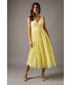 Exquisite lace midi dress with intricate floral pattern
        Flattering V-neckline accentuates the dcolletage
        Elegant bow detail adorns the open back
        Fitted waist creates a feminine silhouette
        Scalloped hem adds a delicate finishing touch
    
    Make a lasting impression at your next special occasion with this stunning lace midi dress. The intricate floral pattern and scalloped hem create a romantic and sophisticated look, perfect for weddings, garden parties, or race day events. The V-neckline and fitted waist flatter your figure, while the open back with a charming bow detail adds an unexpected twist. Style this versatile piece with strappy heels and a clutch for a polished ensemble. For a more relaxed yet equally chic look, pair it with block-heeled sandals and delicate jewellery. The midi length offers both elegance and practicality, allowing you to dance the night away in comfort. This dress is a true wardrobe staple that will see you through countless special events with grace and style.