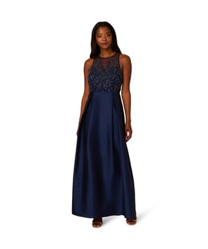 A pinnacle of glamor, youll love getting dressed up in this sleeveless ball gown. The bodice of this exquisite gown is adorned with an all-over beaded embellished mesh knit fabric, catching the light with every step. A crew neckline and illusion sweetheart bodice add sophistication and allure, while the flowing taffeta skirt exudes luxury and grace. Finished with a discreet zipper at the center back, this gown ensures a flawless fit and effortless movement, making it perfect for black-tie events where timeless style and sophistication are essential.