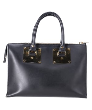 VINTAGE, NEUPREIS WIE NEU  
Die Sophie Hulme Saddle Albion Box Tote aus schwarzem Leder ist ein luxuriöses, zeitloses Stück, das Stil und Funktionalität mühelos vereint. Hergestellt aus glattem, reich gefärbtem Sattelleder, bietet diese kompakte Tote eine strukturierte, kastenförmige Silhouette, die sowohl für den Tag als auch für die Nacht perfekt geeignet ist. Der elegante Reißverschluss an der Oberseite sorgt dafür, dass Ihre Essentials sicher verstaut sind, während die doppelten, gerollten Griffe und der abnehmbare Schulterriemen vielseitige Tragemöglichkeiten für jeden Anlass bieten. Abgerundet mit charakteristischer, vergoldeter Messingbeschlägen und Nieten, strahlt diese Tote unaufdringlichen Luxus aus. Die innere Stecktasche sorgt für Ordnung, und der signature Staubbeutel schützt sie, wenn sie nicht verwendet wird.

Sophie Hulme Saddle Albion Box Tote Tasche in schwarzem Leder  
Zustand: Gut  
Gebrauchsspuren: Kein Einzelhandelsetikett, keine sichtbaren Gebrauchsspuren. Gebraucht, aber gut gepflegt. Mäßige Lederkratzer und abgenutzte Ecken.  
Verpackung: Keine  
Farbe: Schwarz  
Material: Leder | Leder  
Größe: Einheitsgröße | Einheitsgröße  
Maße: Breite: 160; Höhe: 200; Länge: 310; Grifflänge: 420; Riemenlänge: 0  
SKU: TONPUDEBA462814W