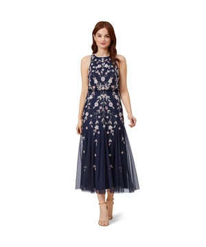 Brilliant blooms take their place on this gorgeous tea-length dress. Featuring a fitted, sleeveless bodice and full skirt, this beaded dress brings the sparkle and romance. Sequins and beads team up into embroidered florals in a mirrored design that flatters the figure. Beading accents the hems at the neck and arms. A zipper back closure finishes the design of this floral beaded dress. Complete the look with metallic heels and a SHUG for added warmth on an evening out.