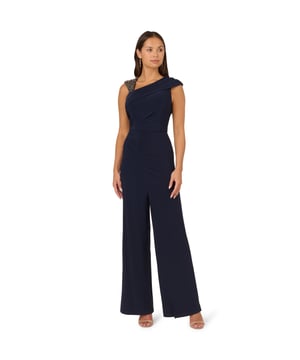 Create a look that sparkles in this wide leg jersey jumpsuit. This jumpsuit features a fitted bodice with shirring at the waist and sleeve, an asymmetrical neckline, and wide legs. Crafted from jersey fabric that has a nice level of stretch for all-night comfort, this jumpsuit is beaded at the shoulder strap. A hidden zipper closure at the centre back completes this dressy jumpsuit. Paired with metallic high heels and sparkling jewellery, this jumpsuit will shine from cocktail attire events to formal weddings.