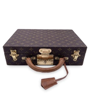 VINTAGE, UVP WIE NEU

Genießen Sie die Kunst des Luxusreisens mit dem Louis Vuitton Monogram 'Boite Bijoux' Schmuck-Reise-Tropp, einem wirklich prächtigen und zeitlosen Accessoire für den anspruchsvollen Reisenden. Hergestellt aus dem ikonischen Louis Vuitton Monogramm-Canvas, ist dieses Etui ein Inbegriff von Eleganz und verfügt über einen klassischen Ledergriff und goldene Messingbeschläge, die Raffinesse ausstrahlen. Entworfen, um Ihren wertvollen Schmuck sicher und geschützt aufzubewahren, bietet es zwei Stauraumfächer, die durch ein abnehmbares Fach mit 13 unterschiedlich großen Fächern wunderschön organisiert sind, ideal für all Ihren Schmuck, von Ringen bis Halsketten. Das Innere ist mit reichhaltigem braunem Samt ausgekleidet, was einen Hauch von Opulenz und Schutz für Ihre wertvollen Stücke hinzufügt. Sicher mit einem eleganten S-Verschluss und zwei robusten Trunkschnallen verschlossen, gewährleistet das Etui sowohl Stil als auch Funktionalität. Innen bestätigt das 'LOUIS VUITTON - Made in France'-Prägung die makellose Handwerkskunst. Ein Stück wie dieses ist nicht nur ein Luxus; es ist eine Aussage über feinen Geschmack und Erbe. Mit einem Einzelhandelspreis von 8000 € im Louis Vuitton Online-Shop ist diese Boite Bijoux mehr als nur eine Schmuckschatulle - es ist ein zeitloser Schatz, perfekt für sowohl die Ausstellung als auch das Reisen. Ob Sie es Ihrer Sammlung hinzufügen oder ein auffälliges Geschenk suchen, dieses exquisite Stück repräsentiert den Inbegriff von Louis Vuittons Engagement für Handwerkskunst und Design. 

Zustandsbewertung: B - SEHR GUTER ZUSTAND
Zustandsdetails: Einige normale Gebrauchsspuren auf dem Samtfutter. 4 Samtpolster fehlen; sie wurden durch 4 maßgefertigte Polster ersetzt (siehe Bilder). Einige normale Gebrauchsspuren auf den Beschlägen. Minimale Verfärbung am Griff. Einige Kratzer auf der Leder-Clochette. Bitte sehen Sie sich die Fotos an und/oder fragen Sie nach, wenn Sie Zweifel haben oder mehr Informationen benötigen.
Maße (cm): 
Tiefe: 10,2 
Höhe: 25,4 
Länge: 34,3 
Weitere Details: Staubbeutel? Nein 
Schlüssel? Ja 
Box? Nein 
Maße: Breite: 102 mm Länge: 343 mm Höhe: 254 mm