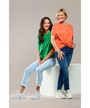 De oranje Selby top is een absolute must-have dit seizoen. Dit t-shirt combineert een tijdloze uitstraling met een moderne touch dankzij de asymmetrische overslag op de boord. De korte drop-shoulder mouwen met stijlvolle omslagdetails geven de top een speelse en elegante look. Met zijn losse pasvorm en iets langere achterkant biedt hij zowel comfort als een flatterend silhouet. Vervaardigd uit 100% katoen voelt de Selby top heerlijk licht en ademend aan – ideaal voor warme zomerdagen. Draag hem met een slim-fit jeans en witte sneakers voor een frisse, casual look. Op koelere dagen maak je de outfit compleet met een denim jacket zoals de Helsinki. Een veelzijdige en stijlvolle toevoeging aan je garderobe!