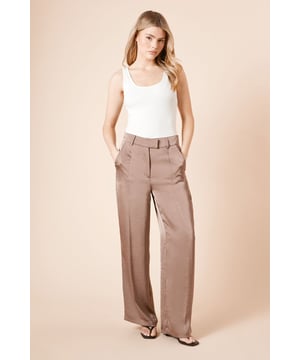 Luxurious satin finish that catches the light beautifully
        Straight leg silhouette for a timeless, flattering fit
        High-rise waistband with belt loops for versatile styling
        Practical side pockets for convenience
        Tailored design offering a sophisticated drape
    
    These Dorothy Perkins tailored trousers combine elegance with everyday wearability. The lustrous satin fabric creates a refined appearance whilst the straight leg cut ensures all-day comfort and a flattering silhouette. Perfect for special occasions, pair with a fitted blouse and strappy heels as shown for a sophisticated ensemble at weddings or formal gatherings. For daytime events such as baby showers or brunch with friends, style with a simple camisole and flat sandals for an effortlessly chic look. The versatile design transitions seamlessly from day to evening, making these trousers a wardrobe essential for the woman who appreciates timeless style with a contemporary twist. The high-rise waist creates a sleek profile that works beautifully with both tucked-in tops and cropped styles.