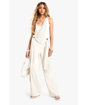 Wrap-style trousers with straight leg design
        Distinctive tie detail at the waist
        High-waisted silhouette for a flattering fit
        Flowing crepe fabric for effortless movement
        Versatile piece suitable for various occasions
    
    Make a statement with these chic wrap-style trousers, perfect for the fashion-forward woman who loves to stand out. The straight leg cut offers a modern twist on a classic silhouette, while the eye-catching tie detail at the waist adds a touch of drama. Pair these trousers with a cropped top and strappy heels for a night out with friends, or dress them down with a simple tee and trainers for a more casual look. The high-waisted design elongates your legs and cinches in your waist, creating a sleek and sophisticated silhouette. Whether you're heading to a trendy rooftop bar or meeting up for cocktails, these trousers will ensure you're always dressed to impress. The flowing crepe fabric moves beautifully with every step, making them ideal for dancing the night away or simply strutting your stuff on the city streets.