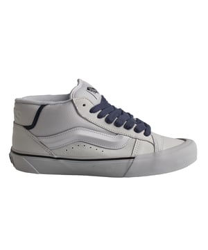 Zapatillas Vans Knu Mid

Una versión moderna del estilo clásico de los años 90, con una lengüeta acampanada y Sidestripe™ moldeado en 3D, un logotipo de Vans en relieve en el cuello trasero y una suela exterior de goma tipo waffle característica que celebra el Old Skool original al tiempo que combina la herencia con las tendencias modernas.

Detalles:
- Modelo de caña media.
- Cuello y lengüeta acolchados.
- Banda lateral Sidestripe™ moldeada en 3D.
- Parte superior de piel y textil.
- Etiqueta tejida en la lengüeta. 
- Distintiva suela waffle de caucho.
- Cordones planos gruesos.

Las zapatillas Vans son mucho más que un calzado: representan una actitud, un estilo de vida urbano y rebelde. Ya sea en su clásica silueta Old Skool, en las icónicas Slip-On o en las modernas colaboraciones con artistas y marcas, Vans sigue siendo un símbolo de autenticidad, creatividad y cultura alternativa.
 Composición: Exterior: Piel, Textil; Interior: Textil; Suela: Sintético
 Cuidados:
Limpiar con un cepillo suave y jabón neutro.
Evitar lavar en máquina.
Secar al aire, lejos del sol directo.