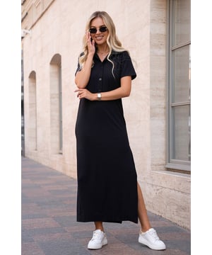 Schwarzes langes Polokleid aus strukturiertem Rippstrick mit kurzen Ärmeln und Kragen. Das Modell mit Knopfleiste und geradem Schnitt ist mit einem seitlichen Schlitz verziert.