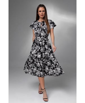 Ein leichtes Kleid mit kurzen, weiten Ärmeln aus weichem Stoff mit Blumendruck. Modell im A-Linien-Schnitt mit Bindeausschnitt und Midilänge. Das Modell mit unterem Volant und Rüschen wird durch einen abnehmbaren Gürtel im gleichen Ton ergänzt.