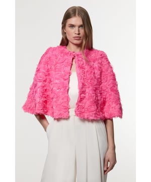 Experience elevated glamour in our cape, which boasts a cropped length, and a textured design with floral appliques. Wear it over a slinky jumpsuit to add an extra level of elegance, or over the matching occasion dress to protect from the elements at upcoming winter events. Textured Rosette Woven Cropped Cape Dramatic Rosette Design Statement Flared Fit Textured, Three Dimensional Floral Applique Cropped Length Matching Dress Sold Separately