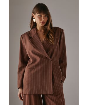 Boxy fit blazer with classic pinstripe pattern for a contemporary twist on tailoring
        Single button fastening creates a clean, streamlined silhouette
        Notched lapel collar adds traditional tailoring detail
        Long sleeves with structured shoulders for a confident, defined shape
        Linen-look fabric offers a textured finish with natural drape
    
    This Warehouse blazer redefines casual sophistication with its relaxed boxy silhouette and distinctive pinstripe pattern. The linen-look fabric creates a textured appearance whilst maintaining a fluid drape that moves beautifully with the body. Style as seen with the matching wide-leg trousers for a coordinated suit that conveys confidence without trying too hard. For daytime engagements, pair with a simple t-shirt and trainers for an effortlessly cool look. When evening calls, swap for a silk camisole and statement jewellery. This versatile piece transitions seamlessly from family gatherings to casual office environments, and even weekend brunches. The relaxed structure makes it ideal for layering over lightweight knits during transitional seasons, whilst the timeless pinstripe pattern ensures this blazer will remain a wardrobe staple for years to come.