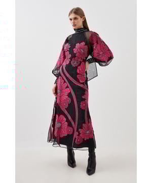 Feel formal in our maxi dress, made with high quality organdie fabric, featuring a fit and flare silhouette that flatters the curves, as well as floral applique accents. Style it with court heels or heeled boots for a look that will take you from party nights and wedding guest days. Applique Organdie Floral Graphic Maxi Dress High Quality Organdie Fabric Comfortable Fit and Flare Silhouette Long Balloon Sleeves Formal, High Neckline Flowing, Sheer Overlay Large, Floral Design Keyhole Back Accent Large Bow Feature Zip Back FasteningBrowse this seasons mother of the bride dresses or shop the full collection of women's wedding outfits now.