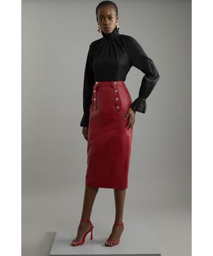 Experience sleek tailoring with our leather pencil skirt. Made with supple leather fabric, a tailored fit and military button detail, this verstaile midi skirt can take you from day to night. Style with knitwear or basic t-shirt and flats for a more casual look, or dress it up with a blouse and heels. Leather Military Button Pencil Midi Skirt High Quality, Soft Real Leather Comfortable High Waistline Belt Loop Features Flattering Tailored Fit Military Button Detail Midi Length