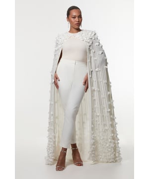 Make a grand entrance at your next formal event with this captivating maxi cape from Karen Millen. The woven fabric serves as a canvas for exquisite floral appliques and sparkling crystal embellishments, creating a mesmerising visual effect. The high neckline and floor-length design lend a regal air to your ensemble, perfect for weddings, galas, or red-carpet affairs. Style this statement piece over a sleek column dress or tailored jumpsuit for maximum impact. Pair with strappy heels and minimal jewellery to let the cape take centre stage. The plus size fit ensures comfort and confidence, allowing you to shine at any occasion. This Karen Millen creation is more than just a garment; it's a work of art that transforms you into the belle of the ball.  Stunning floral applique and crystal embellishments Dramatic floor-length cape design High neckline for an elegant silhouette Woven fabric with intricate detailing Plus size fit for inclusive styling
