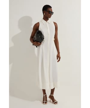 This striking Karen Millen midi dress combines effortless sophistication with modern detailing. The collared halter neckline creates a flattering frame for your decolletage, while the D-ring detail adds a contemporary twist to this daywear essential. As seen on our model, pair with minimalist strappy sandals for a relaxed yet polished look perfect for summer gatherings. The fluid silhouette drapes beautifully to mid-calf, making it ideal for garden parties or casual brunches. Layer with a lightweight denim jacket and trainers for more casual settings, or dress up with statement jewellery and a structured tote for lunch dates. The breathable fabric composition ensures all-day comfort whilst maintaining a refined appearance, making this a versatile addition to your warm-weather wardrobe.  Sleek halter neck design with sophisticated collared detail Distinctive D-ring feature adding contemporary flair Elegant topstitching enhancing the structured silhouette Flowing midi length perfect for versatile styling Woven fabric blend offering comfortable movement and breathability