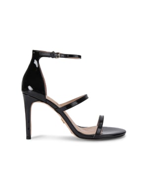 The Kurt Geiger Park Lane heel arrives in a black patent style. The heel is enclosed with gold buckle on the ankle strap as well as small gold branded stud detail at the heel. Heel height: 9.5cm.