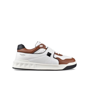 One Stud Sneakers von Valentino Garavani aus weißem Leder.Schwarze Maxi Niete auf der sichtbaren Seite.Schwarzes Valentino Garavani Logo auf der Ferse und der Zunge.Fersenkappe aus schwarzem Leder.Schwarze Konturen.Braune Details.Innensohle aus Leder.Logo-Außensohle aus Gummi mit geprägten Nieten.100% Kalbsleder.Made in Italy.