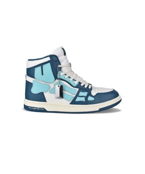 Sneakers altas Skel Top Amiri de piel azul y blanca.Inserciones de cuero azul claro formando un esqueleto.Lengüeta de nailon blanco con logotipo.Placa metálica con el logotipo en la parte delantera.Suela fina de goma azul y blanca con logotipo.Cordones blancos.Puntera redonda.