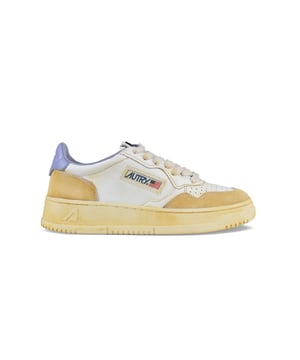 Sneakers bajas Autry Super Vintage de piel blanca y ante beige.Parche con logotipo en el exterior.Contrafuerte de cuero morado.Lengüeta con parche del logotipo.Suela de goma con logotipo. Cierre de cordones.Puntera redonda perforada.100% piel.