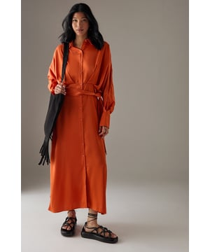 Striking batwing sleeves for a dramatic silhouette
        Elegant midi length with a daring side split
        Collared neckline adds a touch of sophistication
        Button-down front for versatile styling options
        Cinched waist design creates a flattering shape
    
    This satin shirt dress from Warehouse is a versatile piece that effortlessly transitions from day to night. The batwing sleeves create a bold, contemporary look, while the midi length with a side split adds a hint of allure. Perfect for confident women who appreciate edgy yet feminine styles, this dress can be styled for various casual occasions. For a chic daytime ensemble, pair it with ankle boots and a crossbody bag for a family lunch or weekend outing. Layer with a leather jacket for an edgier look when meeting friends for coffee. The button-down front allows for customisable coverage, making it suitable for different settings. Accessorise with statement earrings and a sleek updo for an evening dinner date. The dress's fluid silhouette and rich texture make it a standout piece in any wardrobe, ideal for those who want to make a subtle yet impactful fashion statement.