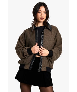 Tall bomber jacket with wool-look texture for added warmth and dimension
        Contrasting PU collar and trim details for a contemporary edge
        Relaxed, oversized fit with dropped shoulders for effortless layering
        Functional side pockets perfect for keeping essentials close at hand
        Ribbed cuffs and hem creating a flattering silhouette whilst retaining heat
    
    This statement bomber jacket combines classic styling with modern proportions, making it the ultimate throw-on piece for your autumn-winter wardrobe. The contrasting PU details add a touch of urban sophistication to the textured body, whilst the relaxed fit ensures comfort without compromising on style. Pair with a cropped top and mini skirt for a night out with friends, or layer over a hoodie with straight-leg jeans and trainers for weekend coffee runs. The versatile design works brilliantly with both casual and dressed-up looks - try it with a slip dress and chunky boots for an unexpected twist on evening attire. Perfect for unpredictable British weather, this Boohoo bomber offers both practicality and fashion-forward appeal in one essential piece.