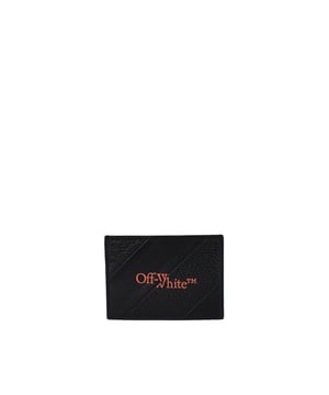 Tarjetero Off-White de piel negra.Rayas diagonales en piel lisa y granulada.Logotipo impreso en la parte delantera de color naranja.Ranuras para tarjetas de crédito y ranura central.100% piel.Made in Italy.