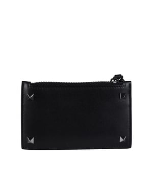 Tarjetero Valentino Rockstud en piel lisa.Color negro.Decorado con cuatro tachuelas de color gris antracita.Espacio para 4 tarjetas.Cierre de cremallera.Dimensiones: Largo: 13,5 cm, ancho: 8 cmMade in Italy.