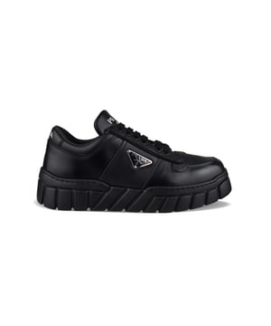 Sneakers de piel negra de Prada.Logotipo triangular de metal esmaltado en el exterior.Parte superior perforada en la parte delantera de la zapatilla.Cierre de cordones negro.Firma Prada blanca en la lengüeta delantera y en el contrafuerte. Suela gruesa de goma.Made in Italy.