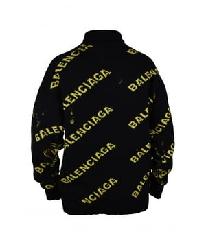 Schwarzer Strickpullover von Balenciaga.Diagonales Balenciaga-Logo in Gelb über den gesamten Pullover.Destroyed-Effekt.Rollkragen.Lange Ärmel.Gerippte Bündchen und Ärmel.Made in Italy.
