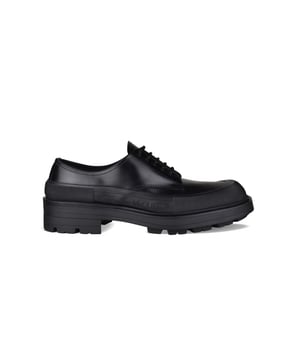 Derbies Alexander McQueen de piel negra.Detalles de costuras.Logotipo en relieve en la lengüeta.Cierre de cordones en negro.Puntera cuadrada.Suela gruesa de goma en contraste con logotipo.Made in Italy.