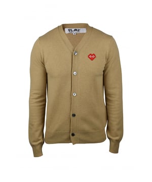 Comme des Garçons vest van kamelenwol.Zwarte knoopsluiting.Emblematisch rood hart op de borst.Lange mouwen.Geribbelde randen.