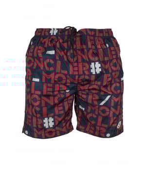 Bañador Moncler de nylon azul oscuro.Logotipos rojos y blancos estampados.Parche con logotipo bordado en la parte inferior.Bolsillos laterales con cremallera.Un bolsillo trasero con cremallera.Cintura elástica.