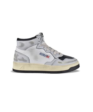 Sneakers Super Vintage Mid Autry en cuero blanco, gris y negro.Parche con logotipo en el exterior. Contrafuerte de cuero gris.Lengüeta con parche del logotipo.Suela de goma efecto vintage.  Cierre con cordones. Puntera redonda perforada.Efecto amarillento y desgastado.100% cuero.