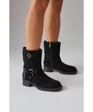 Faux suede chunky biker calf boots
        Mid-heel height between 5 and 6.5cm
        Decorative buckle and strap detailing
        Side zip closure for easy wear
        Sturdy block heel for comfort and stability
    
    Step out in style with these Faith Eostre faux suede chunky biker calf boots. The edgy design combines comfort and fashion, making them perfect for various casual outings. The mid-heel height offers a subtle lift without compromising on wearability, ideal for all-day adventures. Style these versatile boots with a flowy mini skirt and an oversized jumper for a chic autumn look, or pair them with skinny jeans and a leather jacket for a classic biker-inspired ensemble. These boots are your go-to choice for family gatherings, weekend brunches, or casual shopping trips. Their robust construction and timeless appeal ensure they'll be a staple in your wardrobe for seasons to come, effortlessly transitioning from day to night with their adaptable style.