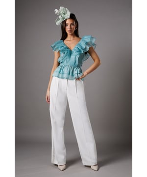Exquisite organza fabric with delicate texture for a refined finish
        Dramatic V-neckline complemented by cascading frills for a feminine silhouette
        Elegant peplum design creating a flattering waistline definition
        Striking open back with ruffle detailing for added drama
        Tiered hem with multiple layers of frills for dimensional movement
    
    This captivating Coast peplum top showcases the beauty of textured organza with its sumptuous frills and feminine detailing. The striking V-neckline frames the dcolletage beautifully, whilst the peplum silhouette creates a figure-enhancing shape that celebrates the waistline. Perfect for summer race days or wedding celebrations, this top pairs wonderfully with tailored wide-leg trousers as styled on our model. Add a statement fascinator and minimal jewellery to complete your occasion ensemble. For evening events, swap the fascinator for chandelier earrings and a sleek clutch bag. The versatile design works brilliantly for garden parties, formal luncheons or champagne receptions where sophisticated dressing is essential. The open back detail adds an unexpected touch of allure to this otherwise classic piece.