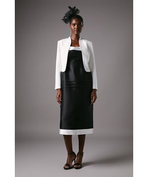 Elegant cropped jacket with sophisticated long sleeves and clean-lined silhouette
        Striking bow detail at the back adds a feminine flourish
        Collarless design with open front creates a sleek, contemporary profile
        Crafted from crepe fabric with slight stretch for comfortable movement
        Fully lined for smooth wear and structured appearance
    
    This beautifully tailored Coast jacket presents the perfect finishing touch for special occasions. The cropped silhouette sits elegantly at the waist, complementing dresses and separates alike, whilst the charming bow detail at the back offers an unexpected twist to a classic design. As shown, pair with a floral midi dress and fascinator for race day sophistication, or style with tailored trousers and a silk camisole for evening events. The clean lines and refined structure make this jacket a versatile investment piece that works brilliantly for weddings, formal gatherings and celebrations. The slight stretch in the fabric ensures comfort throughout the day, whilst maintaining that polished silhouette that Coast is renowned for. Accessorise with delicate jewellery to complete your occasion ensemble with understated elegance.