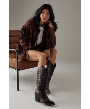 Striking western-inspired calf boots with intricate embroidered detailing
        Brushed faux leather finish for a sophisticated texture
        Pointed toe design with classic pull tabs for easy wear
        Statement 7-9cm block heel adds height whilst maintaining stability
        Calf-height shaft with distinctive western stitching pattern
    
    The Faith Nash Western Boots bring countryside charm to city streets with their distinctive embroidered detailing and brushed finish. The 7-9cm heel creates a flattering silhouette whilst remaining comfortable for all-day wear. Style these versatile boots with a floaty midi dress and oversized jacket for weekend brunches, or pair with straight-leg jeans and a crisp white tee for casual gatherings. For autumn outings, match with a mini skirt and fringed jacket to showcase the boots' western heritage. The pointed toe and sleek silhouette ensure these boots transition effortlessly from day to night, making them a wardrobe essential that combines practicality with statement style. Their classic design promises longevity beyond seasonal trends.