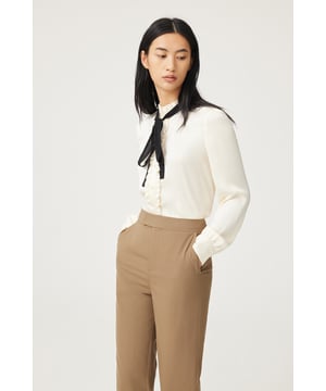 Das verspielte Seidenhemd mit Krawatte ist vom Retro-Trend inspiriert und kreiert einen neuen College-Stil, der voller Energie, aber nicht verspielt ist. Verziert mit femininem Charme, abnehmbarem Design und vielseitigem Styling.