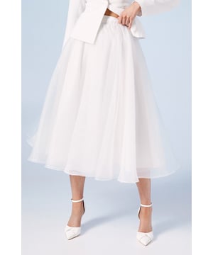 Ethereal organza fabric creates a stunning, floaty silhouette perfect for your special day
        Elegant midi-length design offers a contemporary bridal aesthetic
        Full, voluminous shape provides graceful movement as you walk
        High-waisted fit accentuates your natural waistline beautifully
        Versatile design pairs wonderfully with both fitted and relaxed bridal tops
    
    This enchanting organza skirt embodies bridal sophistication with its dreamy, flowing silhouette. The diaphanous fabric catches the light with every movement, creating a magical effect as you glide down the aisle. Style with the matching tailored blazer for a modern bridal ensemble that reflects contemporary elegance, or pair with a delicate lace top for a more traditional approach. The midi length offers practicality without sacrificing grace, making it ideal for both ceremony and reception celebrations. Complete your bridal look with pointed court shoes and minimal jewellery to maintain the skirt's ethereal quality as the focal point. This versatile piece transitions beautifully from formal wedding settings to more intimate celebration moments, ensuring you feel every bit the radiant bride throughout your special day.