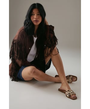 Faux suede sliders featuring striking cow print pattern for a bold statement
        Distinctive metallic eyelet detailing across the wide strap adds contemporary edge
        Comfortable flat heel measuring between 0-2cm for all-day wearability
        Open-toe design with slip-on style for effortless summer dressing
        Cushioned footbed provides essential comfort for casual everyday wear
    
    These Faith Richie sliders combine eye-catching design with practical comfort for your warm-weather wardrobe. The standout cow print and metallic eyelet detailing transform a casual footwear essential into a fashion statement piece. Style these versatile sliders with denim shorts and a simple white tee for relaxed weekend brunches, or pair with a floaty summer dress for garden parties. The flat heel ensures comfort whilst strolling through farmers' markets or enjoying casual family gatherings. For beach holidays, these sliders transition effortlessly from poolside to beachfront caf. Their slip-on design makes them perfect for busy mornings when you need to dash out the door without compromising on style. The neutral tones within the pattern ensure these sliders will complement numerous outfits in your summer collection.