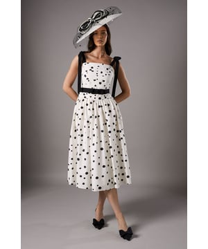 Charming polka dot pattern adorns the entire dress
        Elegant square neckline with contrasting bow-detailed straps
        Fitted bodice with a defined waistband
        Voluminous midi-length skirt for a graceful silhouette
        Crafted from breathable cotton fabric for comfort
    
    Make a statement at your next special occasion with this enchanting midi dress from Coast. The playful polka dot pattern adds a touch of whimsy to the sophisticated silhouette, perfect for garden parties or race day events. The square neckline frames your dcolletage beautifully, while the bow-detailed straps lend a feminine charm. The fitted bodice cinches at the waist before flowing into a full skirt, creating a flattering hourglass shape. Style this versatile piece with strappy heels and a wide-brimmed hat for a classic look, or dress it down with white trainers and a denim jacket for a more casual ensemble. The cotton fabric ensures you'll stay cool and comfortable throughout your event, whether you're sipping champagne at a wedding or cheering on your favourite horse at the races.