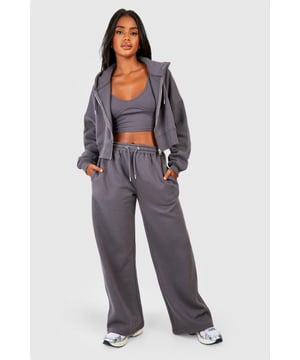 Three-piece tracksuit featuring a crop top, hoodie, and wide-leg trousers
        Seam detail adds a stylish touch to the ensemble
        Fleece-back fabric for comfort and warmth
        Hooded jacket with full-length zip closure
        Wide-leg trousers with an adjustable waistband for a customisable fit
    
    Embrace laid-back chic with this versatile three-piece tracksuit from Boohoo. Perfect for those who want to stay on-trend whilst prioritising comfort, this set is ideal for a range of casual occasions. The crop top can be worn alone on warmer days or layered under the hoodie when the temperature drops. The wide-leg trousers offer a contemporary silhouette that pairs beautifully with trainers for a street-style inspired look. For a casual day out, throw on the full set with some chunky jewellery and a cross-body bag. Alternatively, mix and match the pieces with other items in your wardrobe - try the hoodie with skinny jeans or the trousers with a fitted tee for endless styling possibilities. Whether you're heading to a laid-back brunch, running errands, or enjoying a cosy night in, this tracksuit has got you covered with its blend of style and comfort.